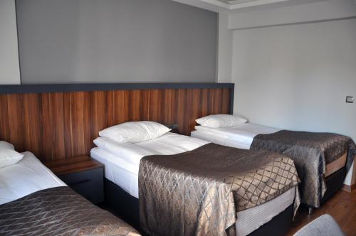 a hotel room with three beds in it at SAKA LİFE OTEL in Erzurum