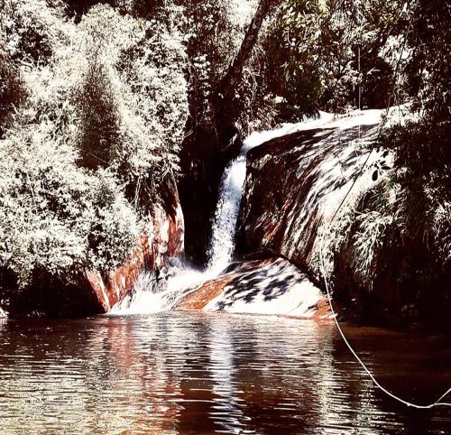 a waterfall on the side of a body of water at Pinheiros do Rocio in Petrópolis