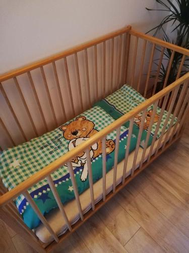 a wooden crib with a teddy bear on it at Apartmá Gister ski and wellnes in Rokytnice nad Jizerou