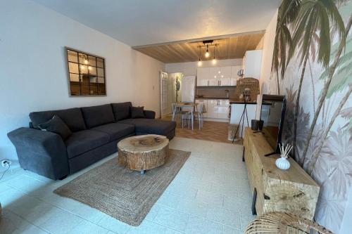 un salon avec un canapé et une table dans l'établissement La Méditerranée Appartement au coeur du Village 50 m de la plage, au Grau-du-Roi