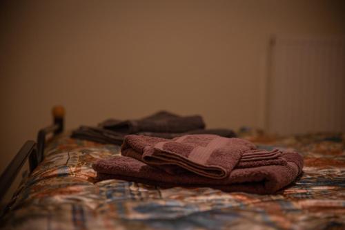 a pile of towels sitting on top of a bed at g.home in Tríkala