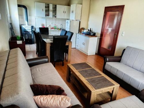 a living room with couches and a table and a kitchen at Vikendica Vlahić, Goranci in Mostar