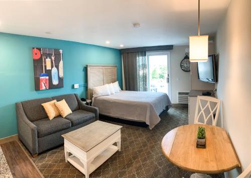 ein Hotelzimmer mit einem Bett, einem Sofa und einem Tisch in der Unterkunft Riverview Resort, a VRI resort in South Yarmouth