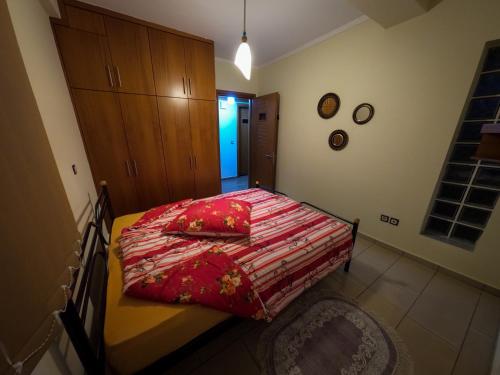 a bedroom with a bed with a red comforter at g.home in Tríkala
