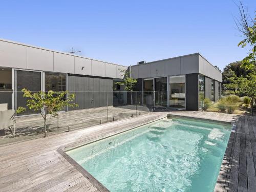 a swimming pool in front of a house at Lahinch Beach House 32 in Torquay