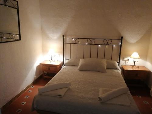 a bedroom with a large bed with two nightstands and two lamps at EL CASTELLET in Traiguera