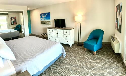 a bedroom with a bed and a chair and a television at Riverview Resort in South Yarmouth