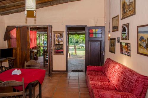 a living room with a red couch and a table at Hostel Mar y Campo in Piriápolis