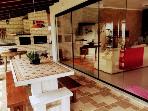 una habitación con una mesa y una pared de cristal en Casa a 150 m da Praia Martins de Sá, en Caraguatatuba