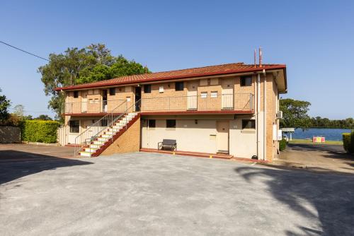 a building with a large parking lot in front of it at Midlands Motel in Taree