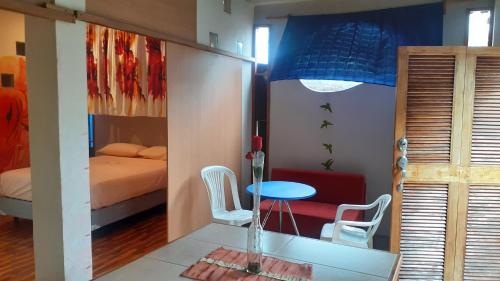 a room with a bed and a table and chairs at Cozy Hosting Galapagos in Puerto Ayora