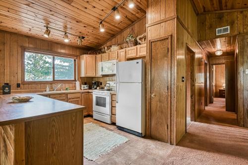 a kitchen with wooden cabinets and a white refrigerator at Trailhead Retreat in Angel Fire