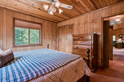 a bedroom with a bed and a dresser and a window at Trailhead Retreat in Angel Fire