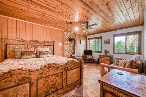 a bedroom with a large bed in a room with wooden walls at Trailhead Retreat in Angel Fire