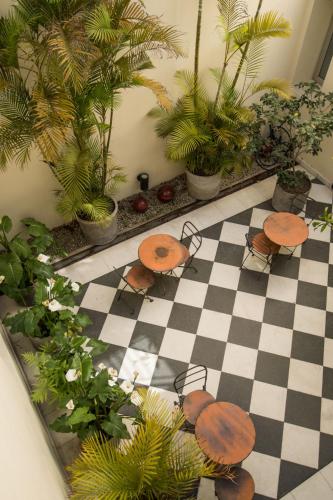 a room with two tables and plants on a checkered floor at Magnolia Hotel Boutique in Buenos Aires