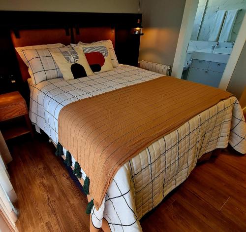1 dormitorio con 1 cama grande y suelo de madera en Wood Borges Gramado, en Gramado