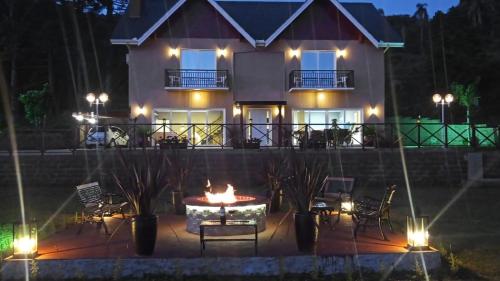 a house with a fire pit in front of it at night at Palast Haus Pousada in Gramado