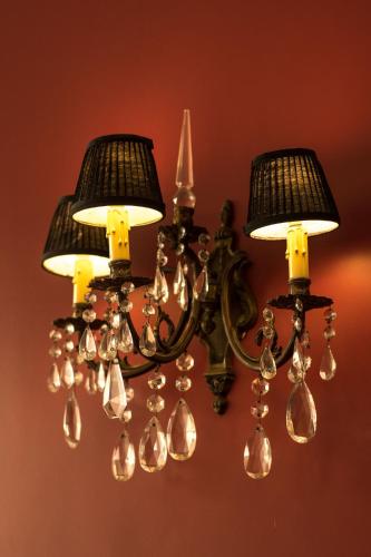 a chandelier with three lights on a wall at Magnolia Hotel Boutique in Buenos Aires
