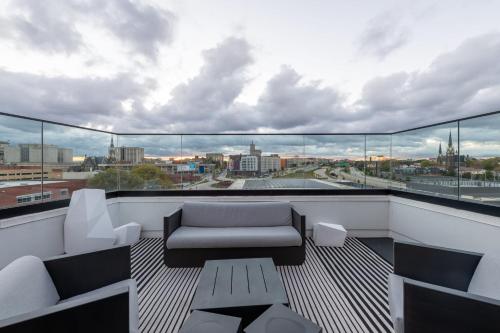 a balcony with a couch and a view of a city at Modern 1BR Apt with Skywalk to Fiserv, Rooftop, and Parking in Milwaukee