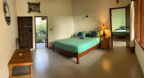 a bedroom with a bed and a table and a mirror at 1000 Dream Bungalow in Lovina
