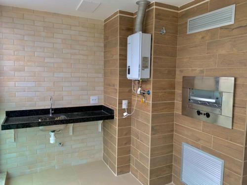 uma casa de banho com um lavatório e um dispensador na parede em Apartamento Praia dos Anjos 2 Vagas de garagem e AR-CONDICIONADO em Arraial do Cabo