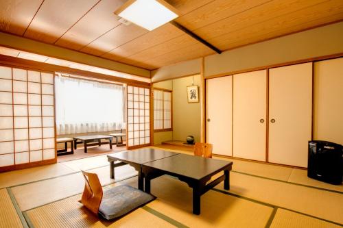 une chambre avec une table, des chaises et une fenêtre dans l'établissement Nara Hakushikaso, à Nara
