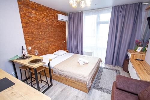 um quarto com uma cama, uma secretária e uma parede de tijolos em Lucky Jet em Novosibirsk