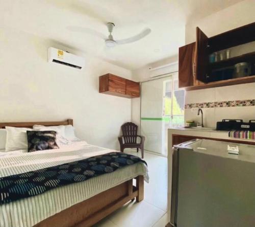 ein Schlafzimmer mit einem Bett und einem Stuhl darin in der Unterkunft Habitacion Coveñitas 201 in Coveñas