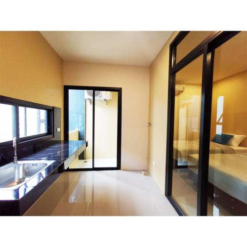 a large bathroom with a sink and a bed at The Middle Town SHA in Chiang Rai