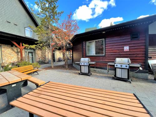 a patio with a picnic table and two bbqs at Renovated Chalet at Mystic Springs, Mountain Views, Pets Welcome! in Canmore