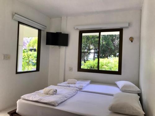two beds in a room with two windows at LayTrang Pakmeng Marina Spa and Resort in Trang