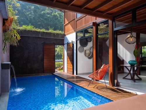 einen Pool mit Terrasse und ein Haus in der Unterkunft JSI Resort in Puncak