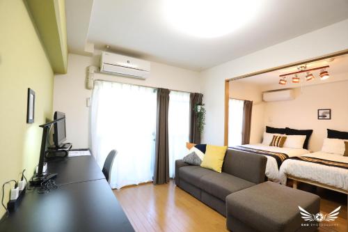 a living room with a couch and a bed at Minoshima Apartment 402 in Fukuoka