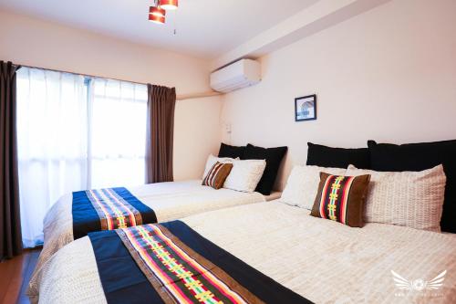 a bedroom with two beds and a window at Minoshima Apartment 402 in Fukuoka