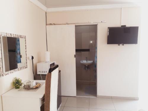 a bathroom with a sink and a toilet and a mirror at Gabade Guest House in KwaDukuza
