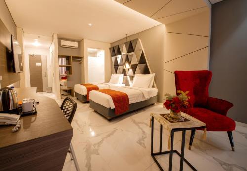 - une chambre avec un lit, un bureau et une chaise dans l'établissement Swiss-Belcourt Kupang, à Oesapa-besar