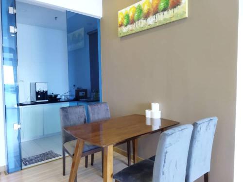 a dining room with a wooden table and chairs at ExcluSuites Malacca @ The Wave Residence in Melaka