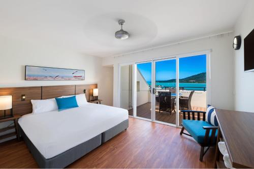 una camera da letto con un letto e vista sull'oceano di The Sebel Whitsundays ad Airlie Beach