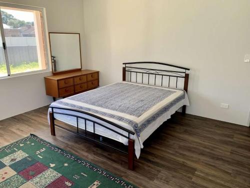 a bedroom with a bed and a dresser and a mirror at Tranquil Waters in Busselton
