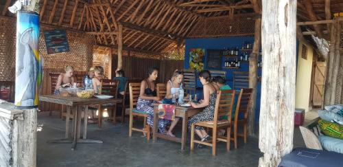 un grupo de personas sentadas en una mesa en un restaurante en Ushongo Beach Bandas, en Pangani