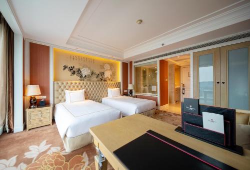 a hotel room with two beds and a television at Tonino Lamborghini Hotel Kunshan City Center in Kunshan