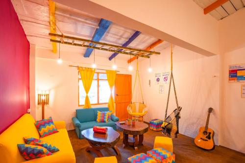 a living room with a swing couch and guitar at goSTOPS Nainital in Nainital