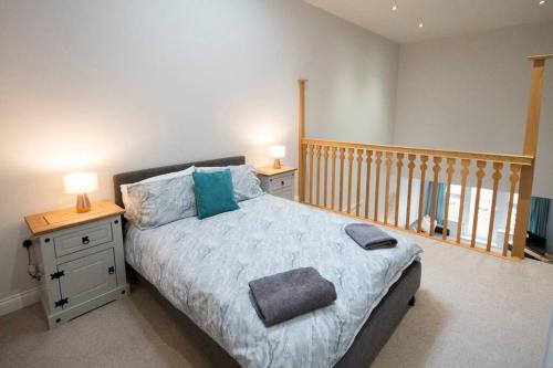 a bedroom with a bed with two night stands and two lamps at Entire Duplex apartment for up to 6 guests, free wifi in Darlington