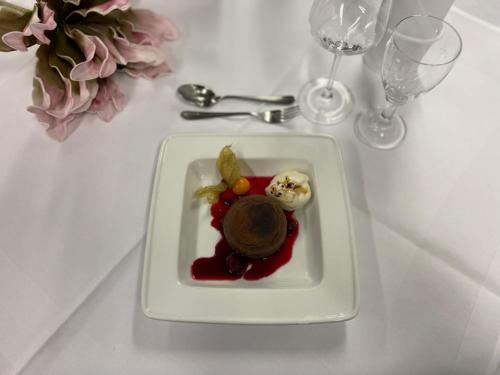 a plate of food on a table with wine glasses at Hotel Krämerbrücke Erfurt in Erfurt