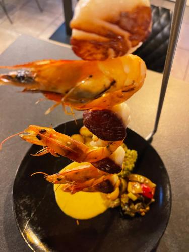 a plate of food with seafood on a table at Logis Hôtel-Restaurant Le Commerce in Rieupeyroux