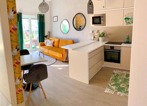 a kitchen and living room with a couch and a table at Apartament Panorama De Lux Family in Koszalin