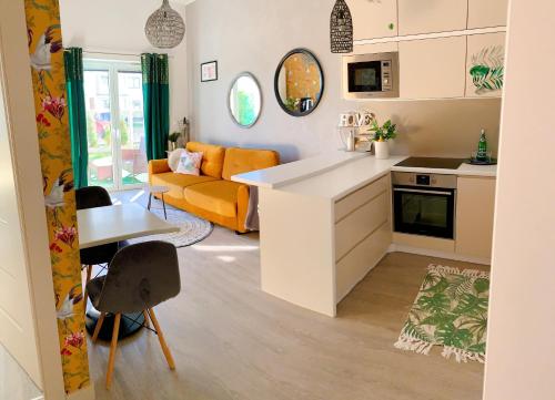 kuchnia i salon z kanapą i stołem w obiekcie Apartament Panorama De Lux Family w Koszalinie