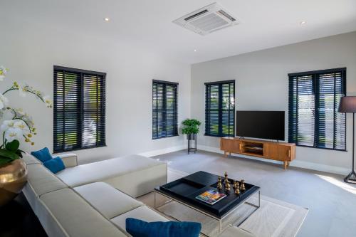 a living room with a white couch and a tv at Luxury 5 Bedroom Pool Villa B11B in Hua Hin