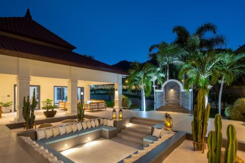 a house with a courtyard with palm trees at Luxury 5 Bedroom Pool Villa B11B in Hua Hin