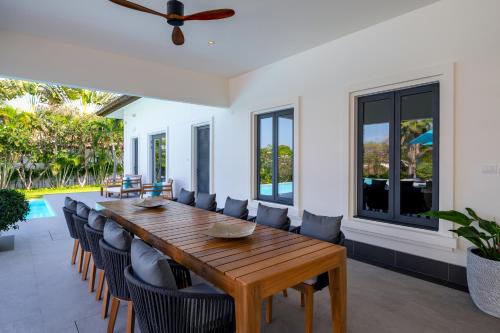 a dining room with a wooden table and chairs at Luxury 5 Bedroom Pool Villa B11B in Hua Hin